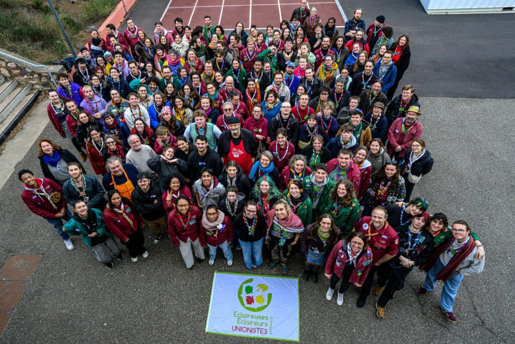Photo de groupe : tous les membres de l'Assemblée générale réunis, vus de haut, posent devant le drapeau des EEUdF étalé au sol